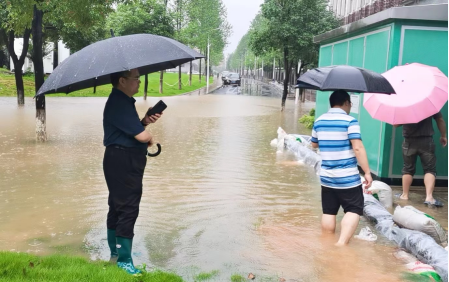 支部书记秦勤忠在变压箱积水前指导防汛工作清理断枝现场变压箱垒放